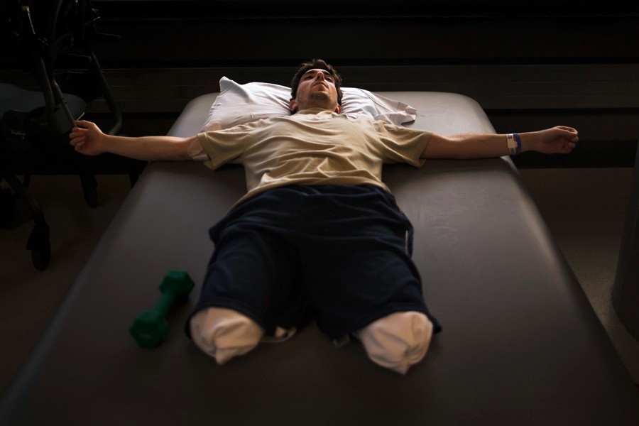 Jeff Bauman rests during occupational therapy at Spaulding Rehabilitation Hospital less than a month after having his lower legs blown off in the first of two pressure cooker bombs that exploded at the Boston Marathon. (Josh Haner, The New York Times - May 8, 2013)