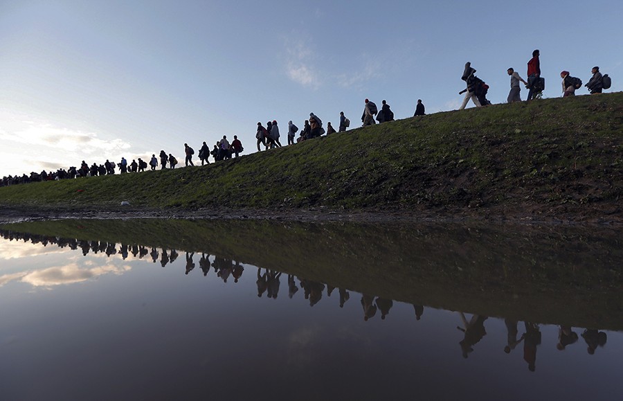 Migrants make their way on foot on the outskirts of Brezice, Slovenia. Slovenia's interior ministry raised the possibility on Tuesday of setting up physical barriers along its southeastern border if the numbers of migrants increased (Srdjan Zivulovic, Thomson Reuters - October 20, 2015).