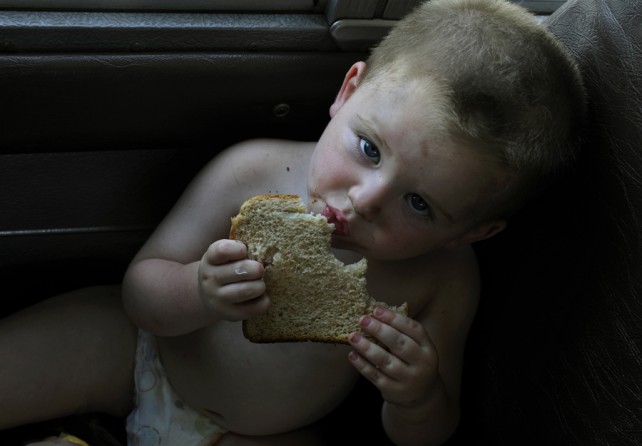 Greeneville, Tenn.: Austin Davis, age 1, munches on a slice of wheat bread (he was too young for a full sandwich) on the Lunch Express bus. The bus is how the Agriculture Department's food-stamp program reaches the kids who rely on free school meals when they are on summer vacation. It visits trailer parks, housing developments and rural homes in the hollows. (July 7, 2013)