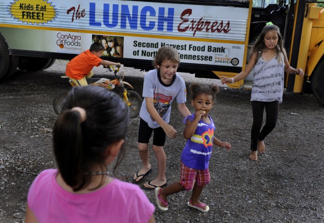 Greenville, Tenn.: Children make their way off the Lunch Express bus after getting a meal. Scores of poor children are served lunch each weekday in the areas around Greeneville. Because so many poor families to not have access to transportation, the bus comes to them. They must eat on the bus, and finish within 15 minutes, because the bus must make many stops over a wide area every day. (July 7, 2013)
