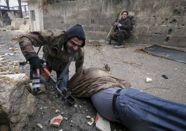 A wounded Syrian rebel fighter drags his comrade who was shot by Army sniper fire during heavy fighting in the Ain Tarma neighbourhood of Damascus January 30, 2013. The fighter on the ground would soon die. (January 30, 2013)