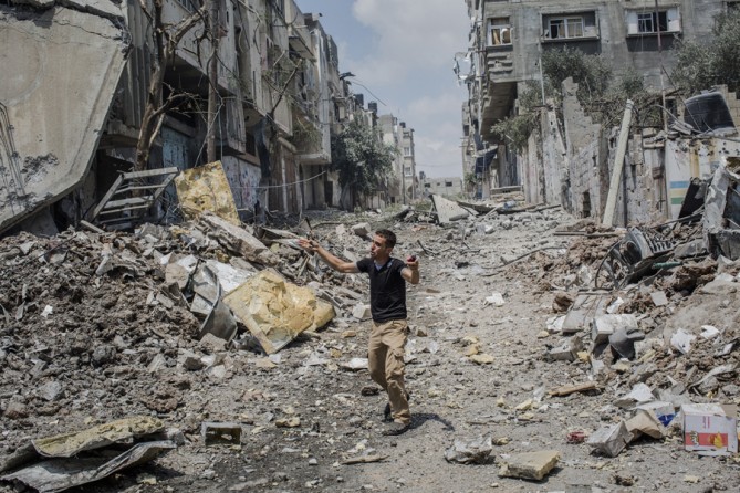 July 20, 2014. A brief cease-fire in the expansion of Israeli military operations allowed ambulance workers to enter the devastated Shajaiya neighborhood in eastern Gaza City, and the last remaining people who remained to flee. (Tyler Hicks/The New York Times)