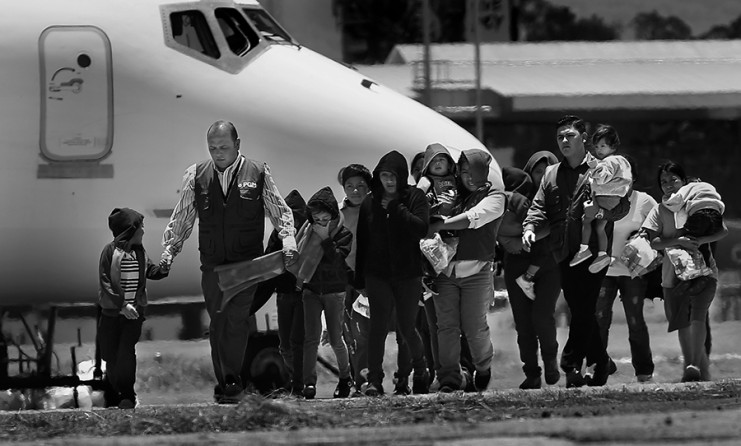Guatemalan Goverment workers, in blue vests, escort mothers with their children from the plane after being deported from the U.S. Three planes, two full of adults and a third full of adults including 7 mothers and 13 children, arrived at the Guatemala Air Force side of La Aurora Airport in Guatemala City, Guatemala, on Tuesday, July 22, 2014. (Bob Owen/San Antonio Express-News)
