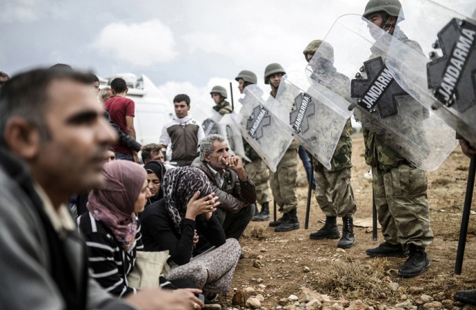 Turkish military forces of the Jandarma (Police Force) block access to the Mursitpinar crossing gate near the Syrian border, as Syrian Kurdish people try to pass, in the southeastern town of Suruc, Sanliurfa province, on September 28, 2014. (Bülent Kılıç/AFP)