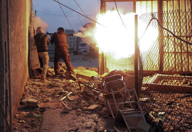 Syrian rebel fighters launch a rocket propelled grenade (RPG) towards an Army checkpoint in the Ain Tarma neighbourhood of Damascus. (January 30 2013)