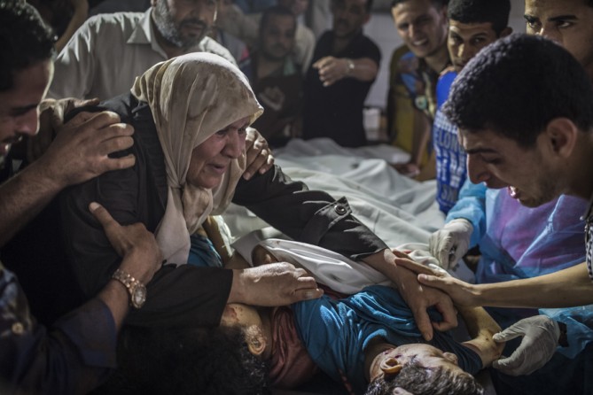 July 17, 2014. Relatives grieve over the bodies of children killed in an Israeli airstrike in Gaza City. (Tyler Hicks/The New York Times)
