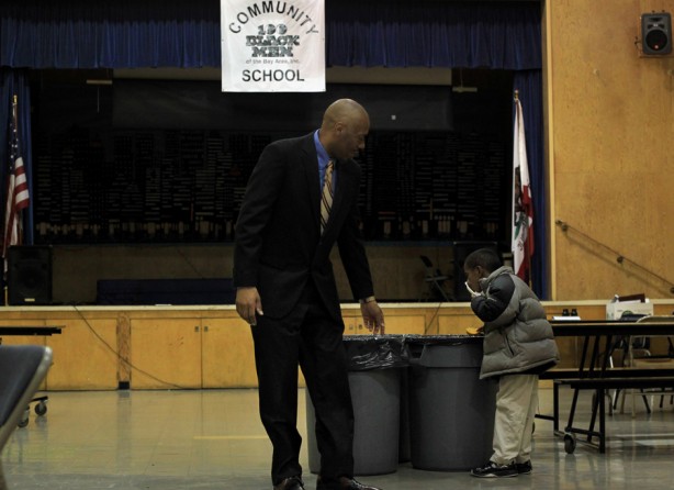 Principal Dr. Stanley Johnson encourages a student to finish his breakfast and go outside for the 'Scholar Holler' before school. In the morning, the students can come early for breakfast - a meal they may not otherwise receive in their homes. (August 25, 2013)