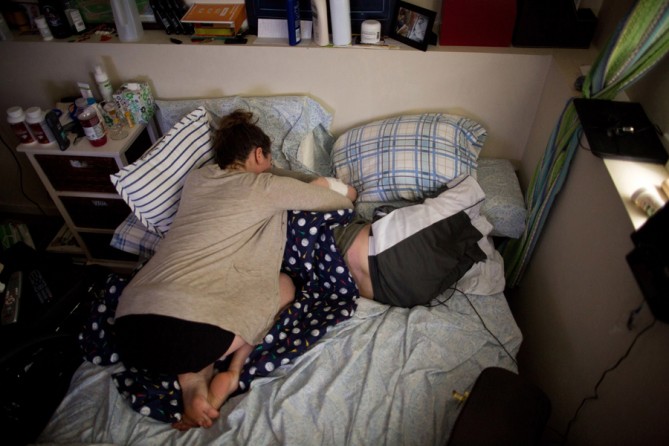 After a long day, Bauman's legs were sore when his girlfriend Erin, arrived. She had recently started doing yoga near his house and was spending most nights sharing his bed at his mother's apartment, living out of her car. (Josh Haner, The New York Times - May 21, 2013)