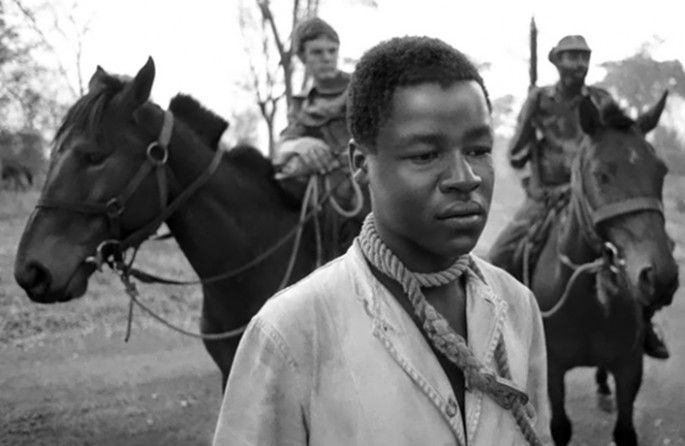 A guerrilla prisoner waits with a rope noose around his neck shortly before white cavalry troopers in the Grey's Scouts drag him behind their cantering horses near the town of Kikidoo in western Rhodesia, 23 September 1977.