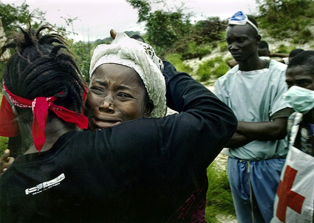 LEARNING THE WORSE: A woman finds that a relative is one of 66 war victims buried in a grave on the outskirts of Monrovia. (Carolyn Cole)