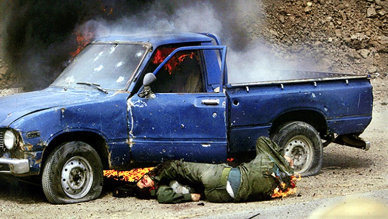 An Iraqi soldier's struggle for life is brief, and ultimately doomed after U.S. soldiers open fire on a truck in northern Baghdad. As flames burn thorugh the back of his uniform, he rolls out of the vehicle onto his dead companion - only to die in another burst of gunfire seconds later. (David Leeson)