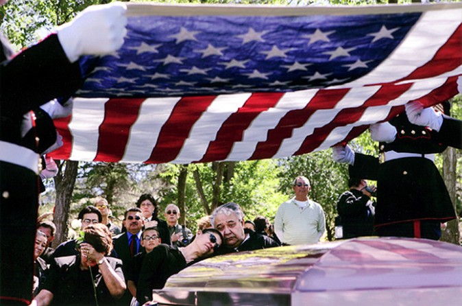 Marines lift the flag off the casket of Lance Cpl. Evenor Herrera, preparing to fold it for the last time and present it to Herrera's parents, Blanca and David Stibbs, center. After watching so many scenes of grief, the Marines involved say the cries of the family never leave their mind. "It's almost enough to wish that you could take his place, so these people wouldn't hurt so much," said Sgt. Kevin Thomas.