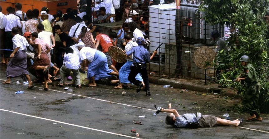A wounded Japanese photographer, Kenji Nagai, lay before a Burmese soldier yesterday in Yangon, Myanmar, as troops attacked protesters. Mr. Nagai later died.