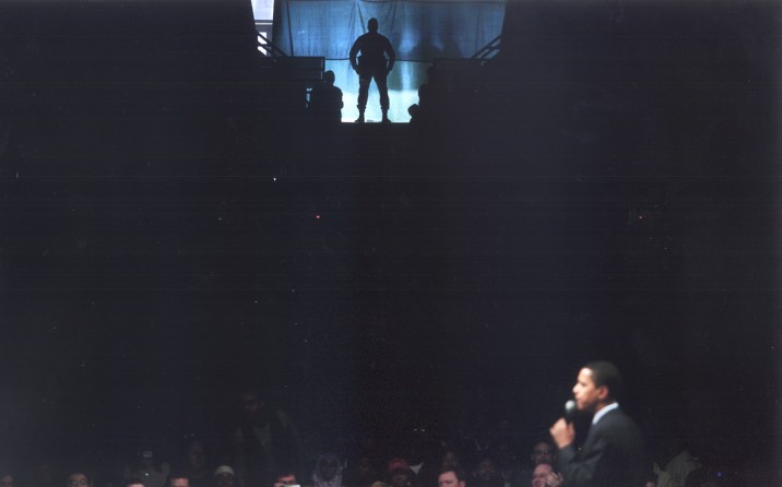 A law enforcement agent keeps watch from an upper-level entrance as Senator Obama spoke to an estimated 10,000 supporters at the University of Alabama in Birmingham.