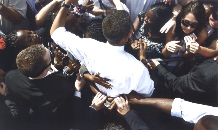 Secret service agents tugging at the hands of a supporter as she hugged Mr. Obama at Legend’s Field in Tampa, Fla.