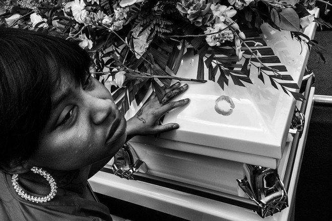 A young woman leaves a lipstick print after kissing Freddie Gray's casket before it is lowered into the ground at Woodlawn Cemetery in Baltimore, Maryland. Gray, 25, was arrested for possessing a switch blade knife April 12 outside the Gilmor Homes housing project on Baltimore's west side. According to his attorney, Gray died a week later in the hospital from a severe spinal cord injury he received while in police custody (Chip Somodevilla, Getty Images - April 27, 2015).