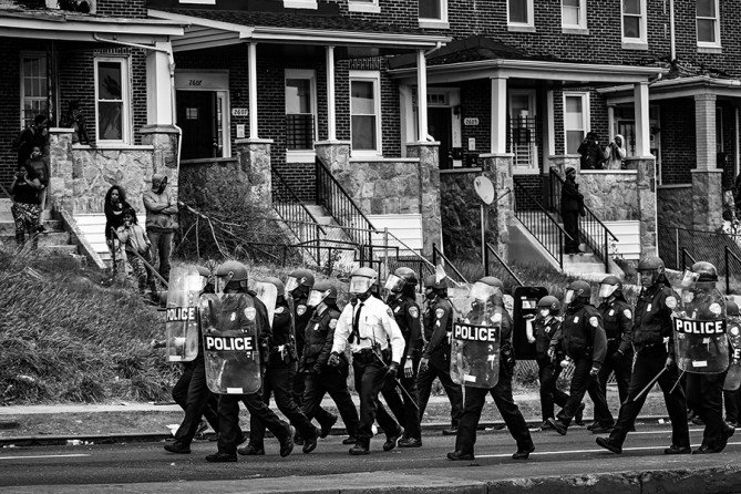 Baltimore Police officers walk in formation on Reisterstown Road near Mowdamin Mall in Baltimore, Maryland. The funeral service for Freddie Gray, who died last week while in Baltimore Police custody, was held on Monday morning (Drew Angerer, Getty Images - April 27, 2015).