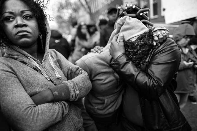 Women comfort each other during a protest against police brutality and the death of Freddie Gray outside the Baltimore Police Western District station in Baltimore, Maryland. Gray, 25, was arrested for possessing a switch blade knife April 12 outside the Gilmor Homes housing project on Baltimore's west side. According to his attorney, Gray died a week later in the hospital from a severe spinal cord injury he received while in police custody (Chip Somodevilla, Getty Images - April 22, 2015).