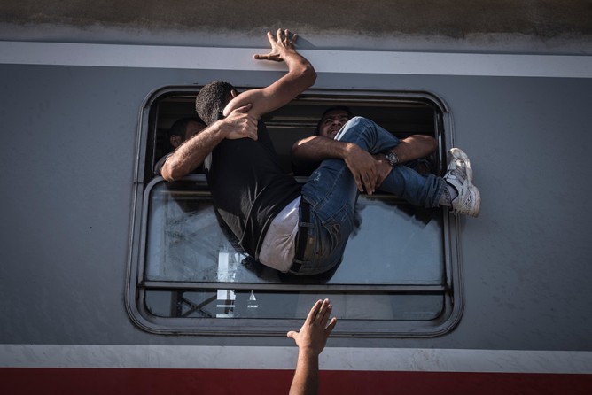 Desperate refugees board the train toward Zagreb at Tovarnik station on the border with Serbia. As key nations tightened their borders, thousands of migrants and asylum seekers were bottled up in the Balkans, placing precarious new burdens on a region of lingering sectarian divisions that was exceptionally ill-prepared to handle the crisis (Sergey Ponomarev, The New York Times - September 18, 2015). 