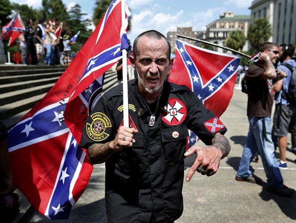 Screaming “white power” while waving Confederate battle flags, members of the Loyal White Knights of the Ku Klux Klan from Pelham, N.C., argue with counter-protesters outside barricades at the South Carolina Statehouse in Columbia. The rally was held to protest a decision by South Carolina lawmakers to remove the Confederate flag from the Statehouse grounds after the mass shooting in Charleston. Images of the Confederate flag figured prominently in an online manifesto of hate posted by the gunman before he
