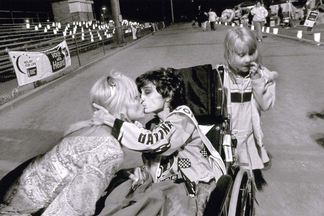 Derek kisses his mom at the Relay for Life benefit, as his 6-year-old sister, Brianna, stands by. Wanting to contribute something to the cause and to "give back," Cyndie recruited volunteers for the benefit. Before the race, Cyndie speaks to the crowd about her pride in her son's bravery during his battle with cancer.
