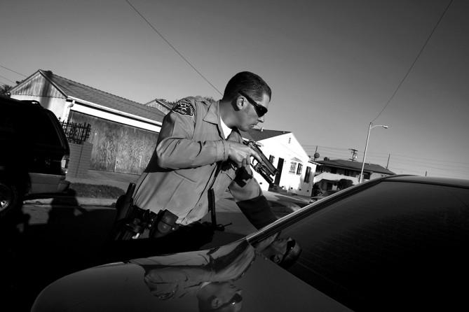In L.A. County homicides fell by nearly a fifth in the first half of 2010, but violence, especially gun violence, remains a plague. Los Angeles County Sheriff's Deputy Derek Fender pulls over a suspected gang member during a patrol. (Barbara Davidson, Los Angeles Times)