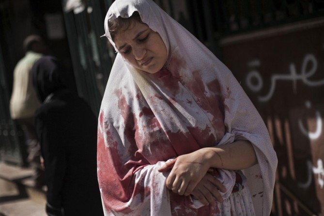 A wounded woman still in shock leaves Dar El Shifa hospital in Aleppo, Syria, Sept. 20, 2012. Dozens of Syrian civilians were killed, four children among them, in artillery shelling by Syrian government forces in the northern Syrian town. (Manu Brabo, Associated Press - September 20, 2012)