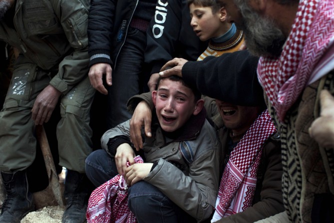 A boy named Ahmed mourns his father, Abdulaziz Abu Ahmed Khrer, who was killed by a Syrian army sniper, during his funeral in Idlib, northern Syria, March 8, 2012. (Rodrigo Abd, Associated Press - March 8, 2012)