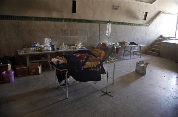 Mahmoud, a 21-year-old Palestinian resident of Syria who would only give his first name, rests in a field hospital after he was found Aug. 6, 2012, with three gunshot wounds in the town of Anadan on the outskirts of Aleppo, Syria. Mahmoud described being the only survivor of a massacre in which he and 10 other men were blindfolded, beaten and sprayed with bullets. (Khalil Hamra, Associated Press - August 6, 2012)