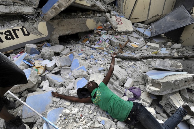 'Shattered Lives' Caked in the dust of crushed plaster and cement, Haitians dug out family members by hand and piled bodies on street corners as clusters of bloodied and dazed survivors pleaded for help. Cindy Tersme throws herself amid the rubble of Ecole St. Gerard, screaming in anguish as she searches for her brother Jean Gaelle Dersmorne, 14. 'I can see my brother’s feet but can't pull him out,' she said, weeping. (Carol Guzy, The Washington Post - January 15, 2010)