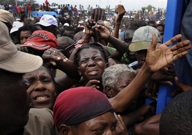 'Desperation' Frantic survivors fight to get in the gate at a food distribution center in Cite Soleil, a slum plagued by poverty even before the earthquake destroyed the area’s fragile infrastructure. The United States and other countries rushed emergency stocks of aid and supplies to Haiti. Like doctors working on a dying patient, foreign governments labored to establish a kind of life-support system that would bring Haiti back. (Carol Guzy, The Washington Post - January 26, 2010)