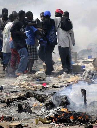 'Burn' The smell of charred flesh lingers as Haitian survivors burn bodies and brandish knives while taking goods from stores in the market. Disorder erupted after the earthquake left Port-au-Prince in ruins. Security emerged as one of the most formidable challenges in the earthquake-shattered capital, limiting the ability of the United Nations and relief officials from elsewhere to distribute food and medicine. (Carol Guzy, The Washington Post - January 18, 2010)