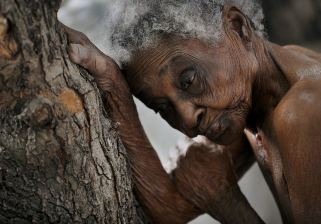 'The Elderly' Idamise Pierre leans against a tree, her withered skin resembling its bark, as she waits to bathe at the Azil Communal Home for the Aging. With weary resignation, the elderly have endured decades of Haiti's poverty and political turmoil and in their twilight years are now left with heavy hearts by the earthquake that eternally altered their lives. (Nikki Kahn, The Washington Post - March 13, 2010)