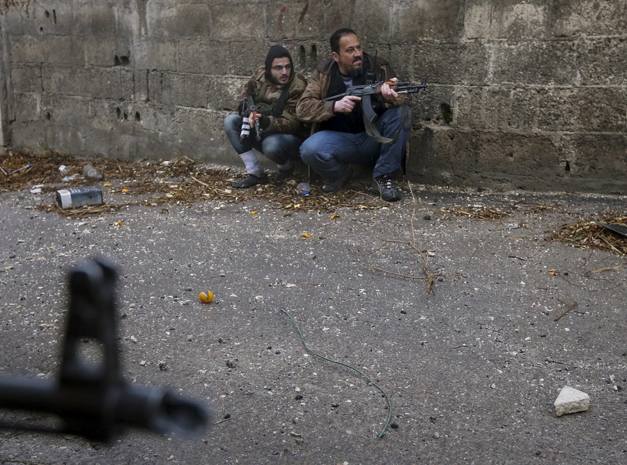 Syrian rebel fighters prepare to attack a government backed Syrian Army checkpoint in the Ain Tarma neighborhood of Damascus on January 30, 2013. A group of rebels planned an attack on a government controlled post but would soon loose a comrade to Army sniper fire. After evacuating their comrade, who would soon die after, the rebels would returned to attack the check post, only to retreat after being hit by a tank shell. After the two hour ordeal, the rebels would return to their base and mourn the lose of 