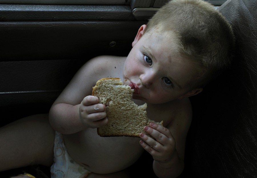 Greeneville, Tenn.: Austin Davis, age 1, munches on a slice of wheat bread (he was too young for a full sandwich) on the Lunch Express bus. The bus is how the Agriculture Department's food-stamp program reaches the kids who rely on free school meals when they are on summer vacation. It visits trailer parks, housing developments and rural homes in the hollows. (July 7, 2013)