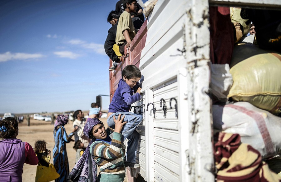 Syrian Kurds get into a truck after crossing the border between Syria and Turkey in Suruc, in the Sanliurfa province, on September 30, 2014. Tens of thousands of Syrian Kurds flooded into Turkey fleeing an attack by the Islamic State (IS) group. (Bülent Kılıç/AFP)