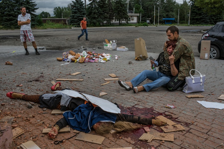 Aug. 19, 2014. A mother is comforted by her son, a pro-Russian rebel, in front of the body of her daughter, who died next to two other people in shelling by Ukrainian troops near a railway in Makeevka, east of Donetsk. (Mauricio Lima for The New York Times)