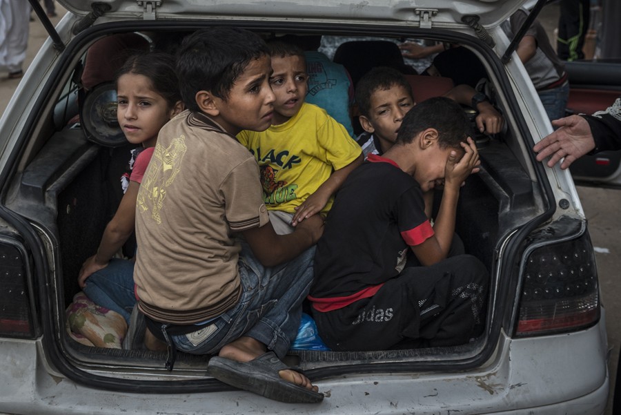 July 23, 2014. Palestinian refugees fleeing fighting in their neighborhood arrive at a United Nations school used as a shelter in Khan Yunis, in southern Gaza. (Sergey Ponomarev for The New York Times)