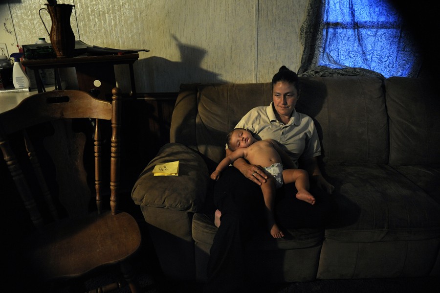 Greenville, Tenn.: Jennifer Laughren holds 9-month-old Sarah after coming home from her second 14-hour shift at a minimum-wage job in two days. She leaves at 4:30 a.m. and gets home at 8:30 p.m. "I'm so tired that I can't even sleep," she says. Because Laughren makes so little money, she needs the meals provided by the lunch bus and her food stamps to be able to pay rent. Laughren has five children, and the bus saves her having to pay for 25 meals a week. (July 7, 2013)