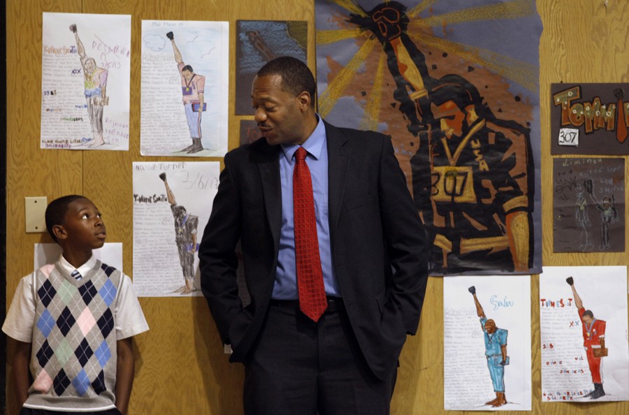 Fifth-grade student Joshua West listens to principal Dr. Stanley Johnson as he talks to him about his behavior while standing among drawings of Tommie Smith, an African American athlete who is known for giving the Black Power salute at the 1968 Olympics. He visits the students at their school once or twice a year. (August 25, 2013)