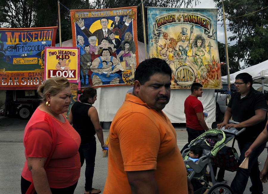 McAllen, Tex.: Residents pass an old-fashioned sideshow at the Alamo Flea Market. The obesity rate around Hidalgo County, one of the poorest and fastest-growing U.S. counties, is 38.5 percent. Children now living in this county are not expected to live as long as their parents.  (November 8, 2013)
