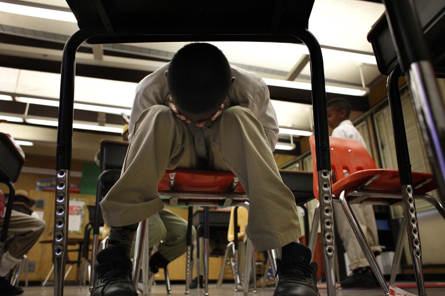 Tired from the day, Jordan Burns holds his face in his hands during Mr. Stafford-Glenn's fourth-grade class. Jordan was ordered several times to sit up straight and pay attention, but out of rebellion he ignored his teacher. (August 25, 2013)