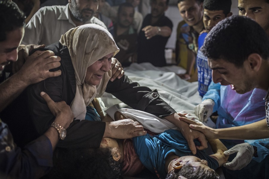 July 17, 2014. Relatives grieve over the bodies of children killed in an Israeli airstrike in Gaza City. (Tyler Hicks/The New York Times)