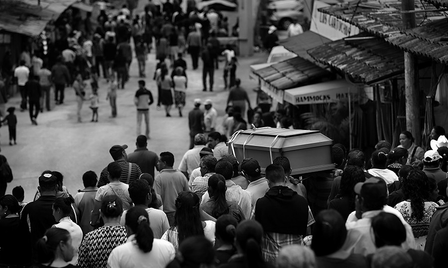 Family members and friends carry the casket and walk in a funeral procession of a 24 year old man shot four times by gang members for not completing a task he was asked to do, in the small colonial town of Valle de Angeles, Honduras, just outside Tegucigalpa. Saturday, July 5, 2014. Tens-of-thousands of Central Americans - many from Honduras - fleeing the increasing violence crossed into the United States in 2014. (Bob Owen/San Antonio Express-News)