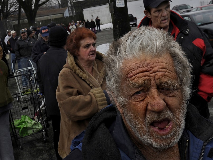 Woonsocket, R.I.: William Bobola, 75, is among scores of Woonsocket residents who have waited in line to get a bag of food at Bryan's Food Pantry in the basement of St. Charles Church. He lives on a fixed income and receives food stamps, but it was the last day of the month and he, like many others), had run out of many food items. He gets food (mostly tuna, peanut butter and pasta) for himself and his 36- year-old daughter, who has a disability and lives with him. Many people in Woonsocket receive food sta