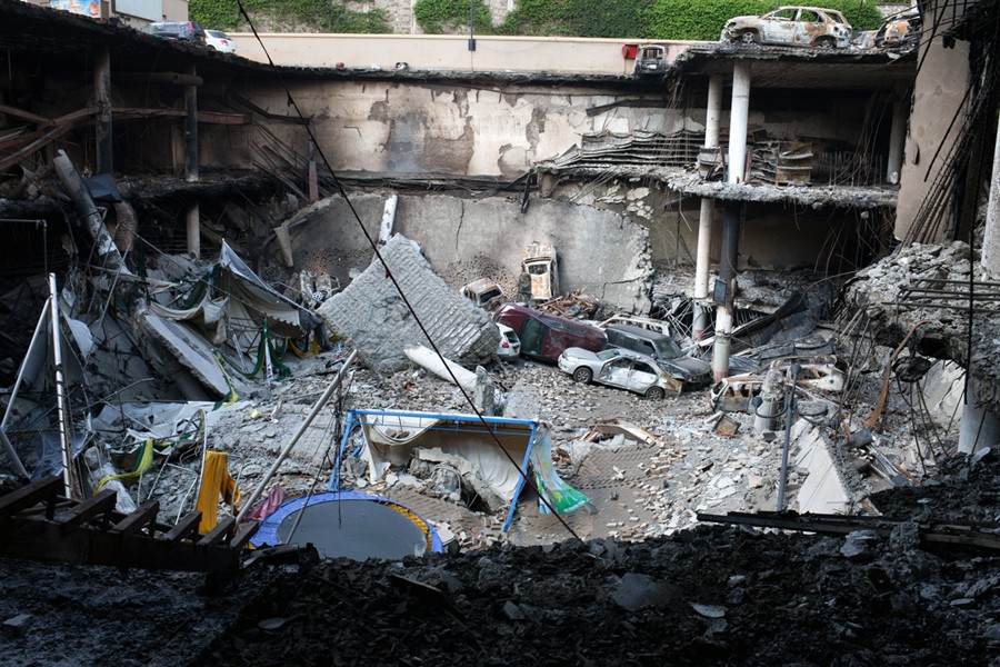 A section of the mall's parking lot crumbled, sending vehicles tumbling into an enormous, smoking pit. (Tyler Hicks, The New York Times - September 30, 2013)