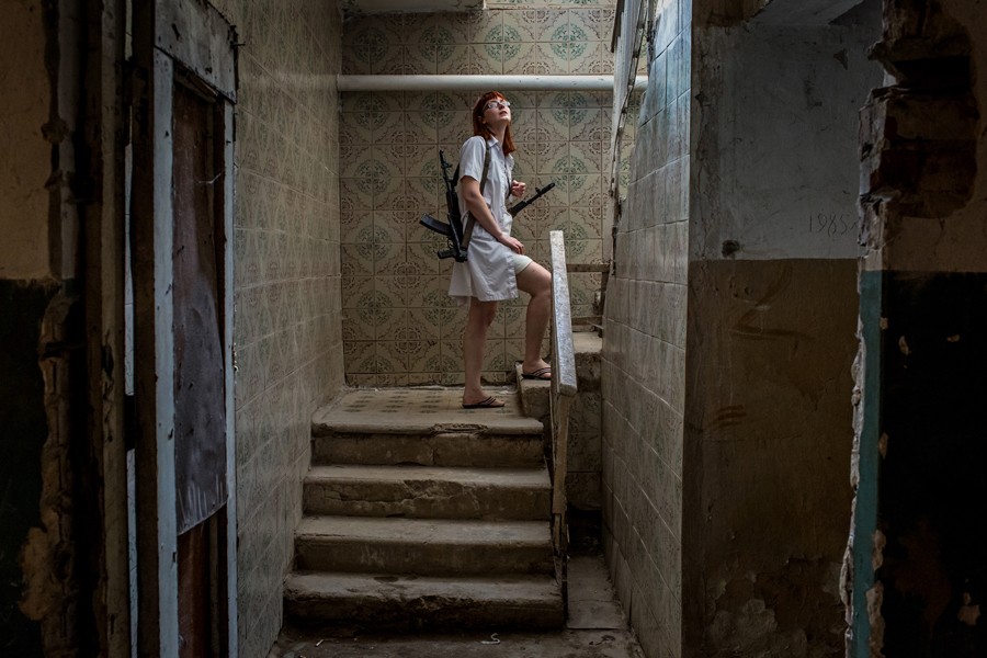 Aug. 24, 2014. A nurse holds rifles of pro-Russian rebels as they help move a patient from a hospital basement after an early-morning shelling in Donetsk, Ukraine. (Mauricio Lima for The New York Times)