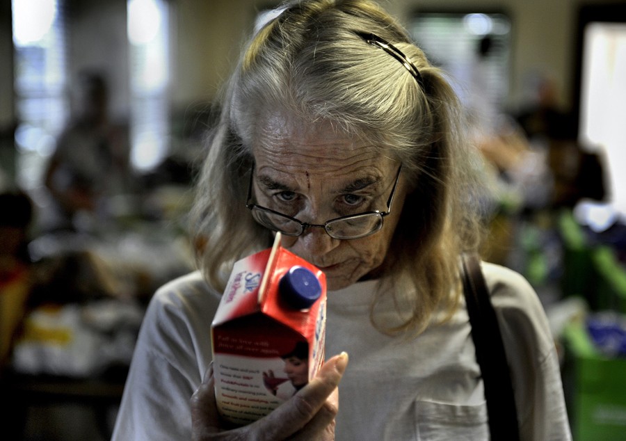 Hobe Sound, Fla.: Marion Mattrazzo checks the expiration date on soy milk at a food pantry. Scores of residents waited to get a box of food, but senior citizens with a number go first. Mattrazzo, 54, suffers from cirrhosis of the liver and lives on about $7,000 per year. She signed up for food stamps because so much of her income goes to health care, and she is not old enough to enroll in Medicare. She had a vibrant construction company before Florida's housing collapse, and her husband died two years ago. 
