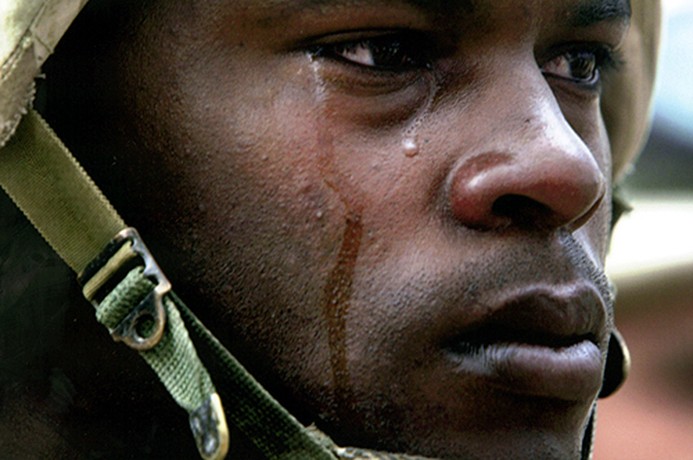 Squad leader and Staff Sgt. Lonnie Roberts stands at attention as troops from the 3rd Brigade Combat Team pay last respects to their fallen comrade, Pvt. Gregory Huxley, during a memorial for the 19-year-old in Baghdad. (David Leeson)