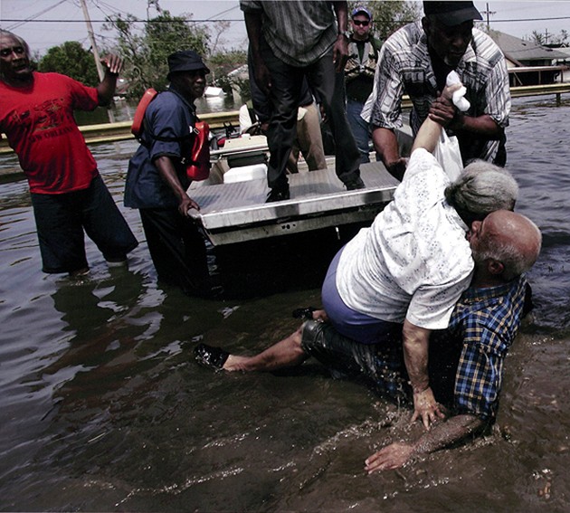 New Orleans, LA -- Ibry Smith (right) fell as he helped Norma Rankins out of a boat after they were rescued from a nursing home in the Ninth Ward. 